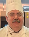Thomas Recinella wearing a chef coat and toque