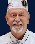Paul Jensen wearing a chef coat and toque