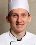 Dylan Obee wearing a chef coat and toque