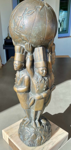 A statue of a person carrying a large bowl.