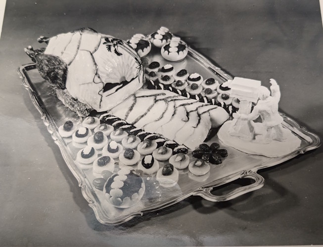A tray of pastries and a statue of a person.