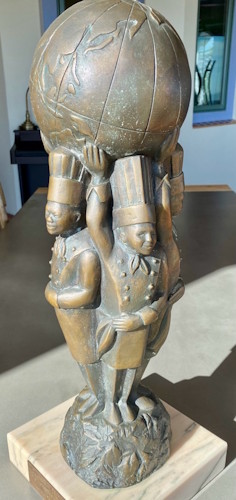 A statue of a person carrying a large bowl.