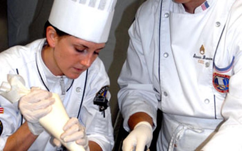 Spc. Michelle Carville and Staff Sgt. Stephen Broome prepare deserts at Grafenwohr on Wednesday during training for the World Culinary Olympics.
